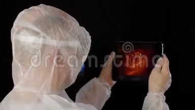 医务人员穿着防护服，在一个科学实验室里用药片做血液测试。 生物工程研究血液运动